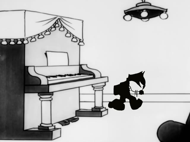 Felix the Cat pacing beside a piano
